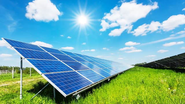 Aurinkopaneelit kesäisessä maisemassa