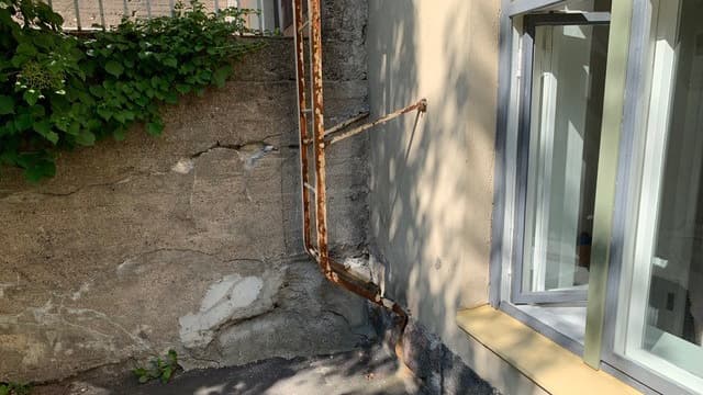 <p data-block-key="hbufp">Taloyhtiön takapihan muurista näkee hyvin pihojen korkeuseron. Muurista huomaa myös kosteuden aiheuttamat rappeumat.</p>