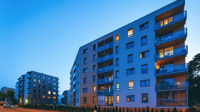 Asuinkerrostalo hämärässä ikkunoissa näkyy valoa