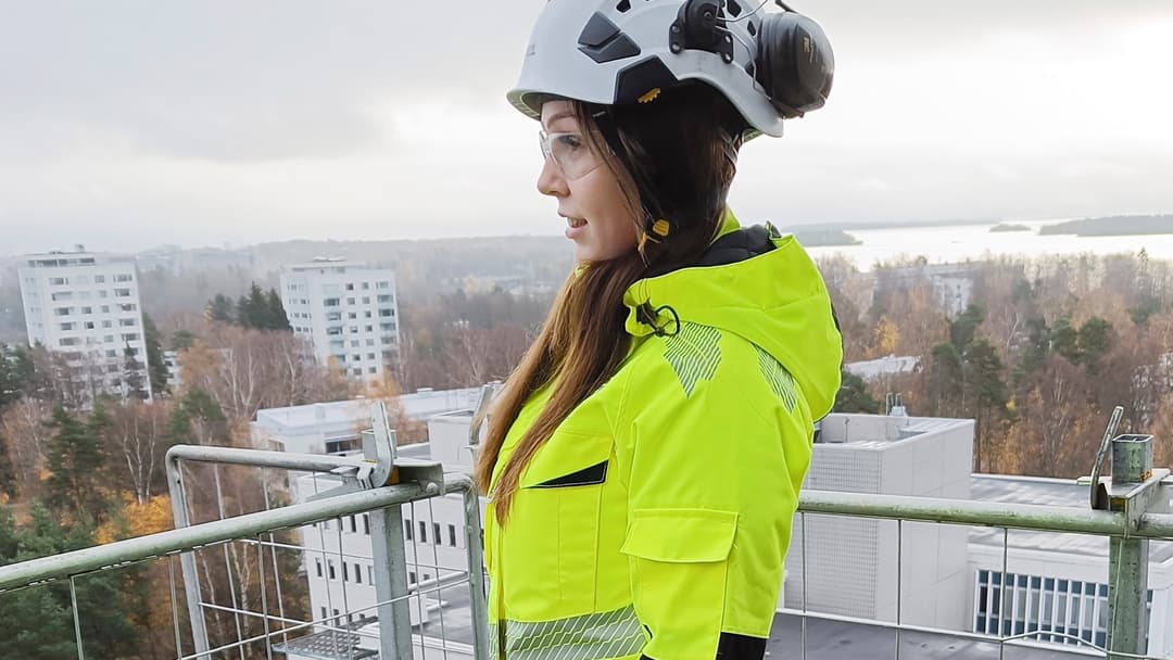 työvaate ja työkenkä testaaja linda seisoo kerrostalotyömaan katolla