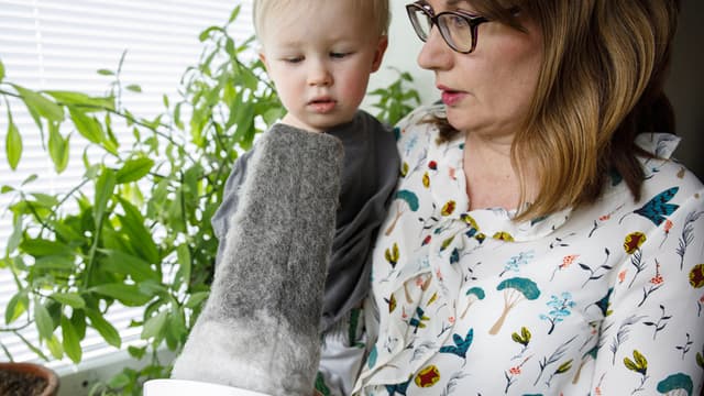 Nainen ja lapsi tutkivat likaista korvausilmaventtiilin suodatinta